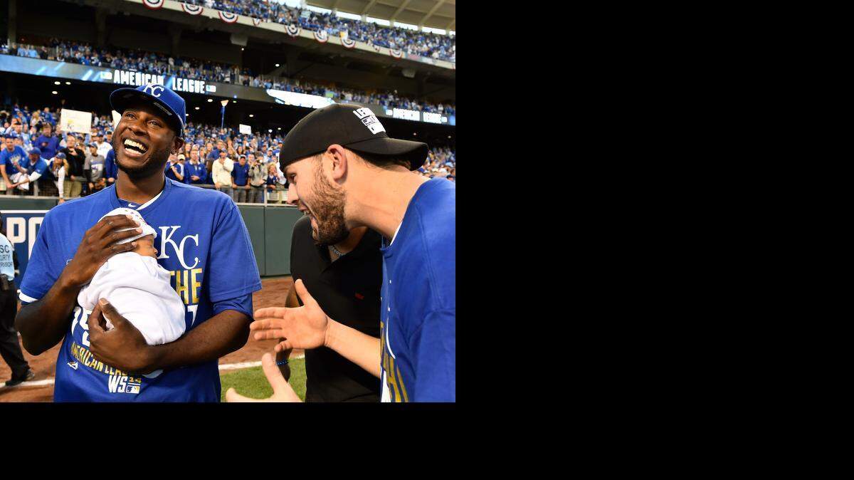 
Royals center fielder Lorenzo Cain holds his son, Cameron Loe, while he and third baseman Mike Moustakas celebrate after the Royals beat the Orioles on Wednesday. 
