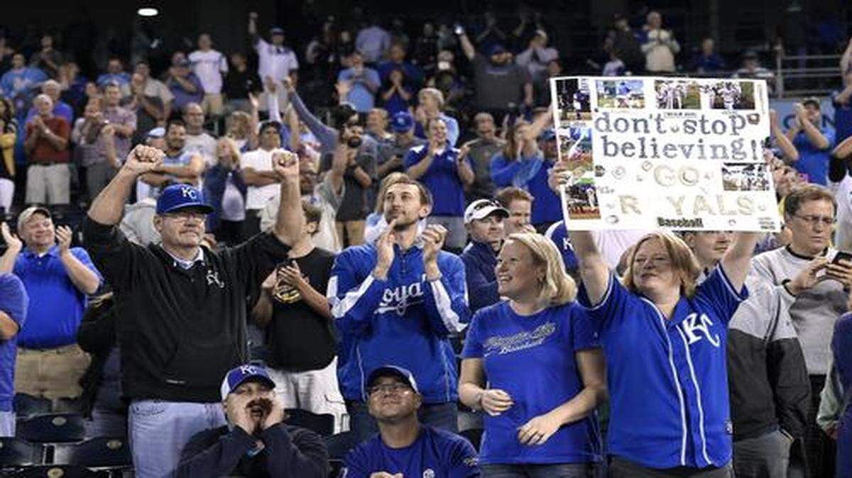 
Kansas City Royals fans Jennifer Bendorf (left center) and her sister Marilyn Kirn (holding poster), both from Lee’s Summit, Mo., celebrated with the crowd after the team’s 6-2 win over the Chicago White Sox on Wednesday at Kauffman Stadium.
