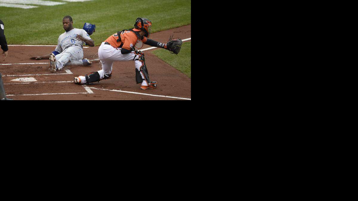 
Kansas City Royals Lorenzo Cain slides safely into home plate after Eric Hosmer connected on the ball pitched by Baltimore Orioles starting pitcher Bud Norris during the first inning. Norichika Aoki also scored on the play at Saturday's ALCS playoff baseball game on October 11, 2014 at Camden Yards in Baltimore, Md.
