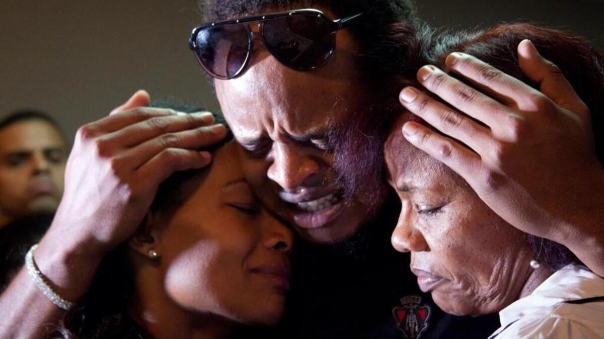 Edinson Volquez, center, embraces his sister Wendy Volquez, left, and mother Ana Ramirez as they stand next to the body of his father Daniel Volquez during his wake at a funeral home in Santo Domingo, Dominican Republic on Wednesday. The Royals’ Volquez pitched in Game 1 of the World Series on Tuesday night, just hours after his father died of heart failure in the Dominican Republic. The elder Volquez, a mechanic, introduced his son to the game when he was about 10 years old.