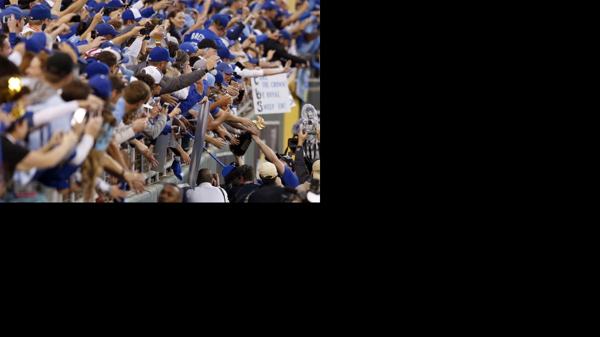 Kansas City Royals fans celebrate with the team as they hold the trophy after the Royals defeated the Baltimore Orioles on Wednesday in Kansas City, Mo.