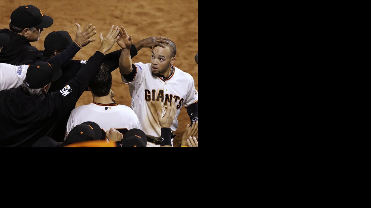 
San Francisco Giants Juan Perez, right, is congratulated after hitting a two-run RBI double during the eighth inning of Game 5 of the World Series on Sunday in San Francisco. The Giants defeated the Royals 5-0. 
