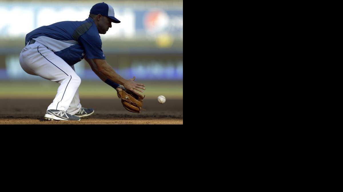 
Kansas City Royals' Jayson Nix handles a ground ball during batting practice before the start of the AL wild-card playoff baseball game against the Oakland Athletics Tuesday, Sept. 30, 2014, in Kansas City, Mo. (AP Photo/Jeff Roberson) 
