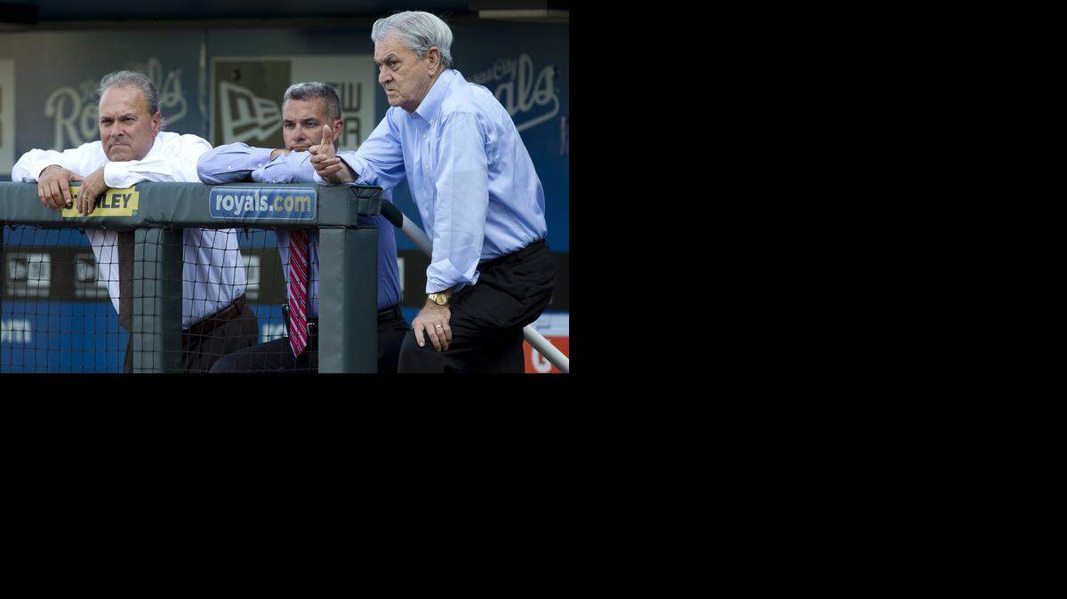 Kansas City Royals owner David Glass (right) visits with team general manager Dayton Moore and team president Dan Glass during batting practice before a game against the Milwaukee Brewers on June 13, 2012, in Kansas City, Mo.