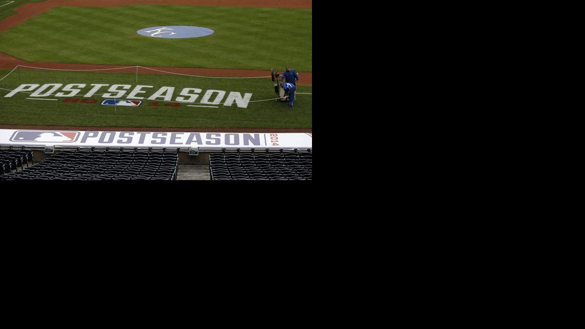 
The ground crew works on the field logo before the teams worked out on their off day during the ALCS baseball series Kansas City, Mo., Sunday, Oct. 12, 2014. The Royals face the Baltimore Orioles in game 3 of the ALCS Monday. 
