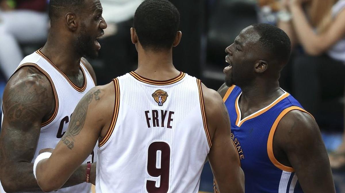 Warriors forward Draymond Green, right, and Cavaliers forward LeBron James, left, argue while being separated by Channing Frye during the second half of Game 4 of the NBA Finals on Friday in Cleveland.