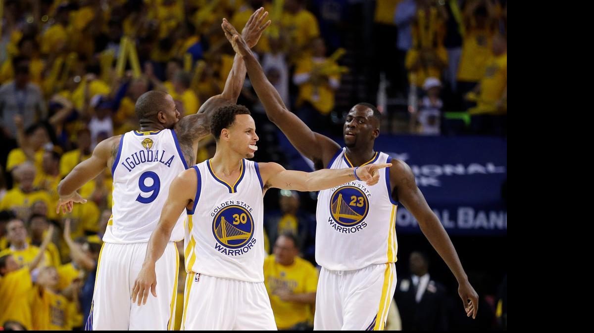 
Golden State guard Stephen Curry, center, forward Andre Iguodala (9) and forward Draymond Green, right, react during the second half of Game 5 of the NBA Finals against Cleveland on Sunday in Oakland, Calif.
