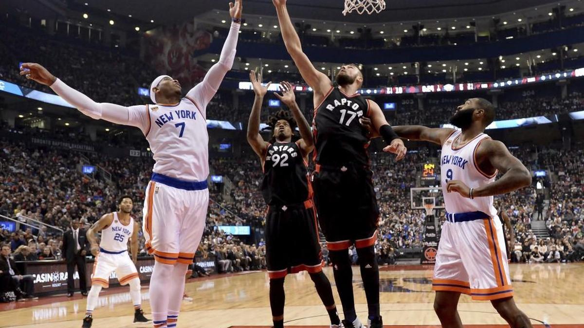 Toronto Raptors centers Jonas Valanciunas (17) and Lucas Nogueira (92) rebound against New York Knicks forwards Carmelo Anthony (7) and Kyle O'Quinn (9) during Sunday’s game between the Raptors and New York Knicks in Toronto.