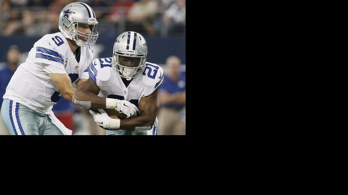
Dallas Cowboys quarterback Tony Romo (9) hands the ball off to running back Joseph Randle (21) during the first half of an NFL football game against the New York Giants, Sunday, Oct. 19, 2014, in Arlington, Texas. 

