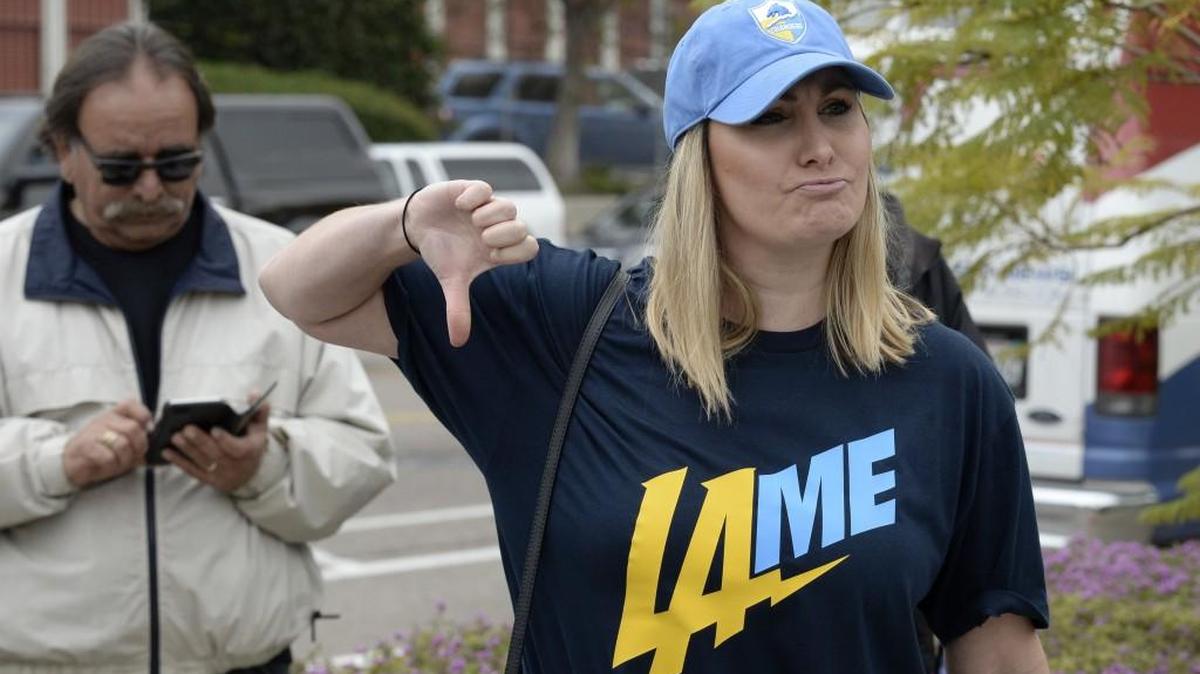 Bre Priest gives the thumbs down while wearing a T-shirt mocking the team at San Diego Chargers headquarters after the team announced that it will move to Los Angeles.
