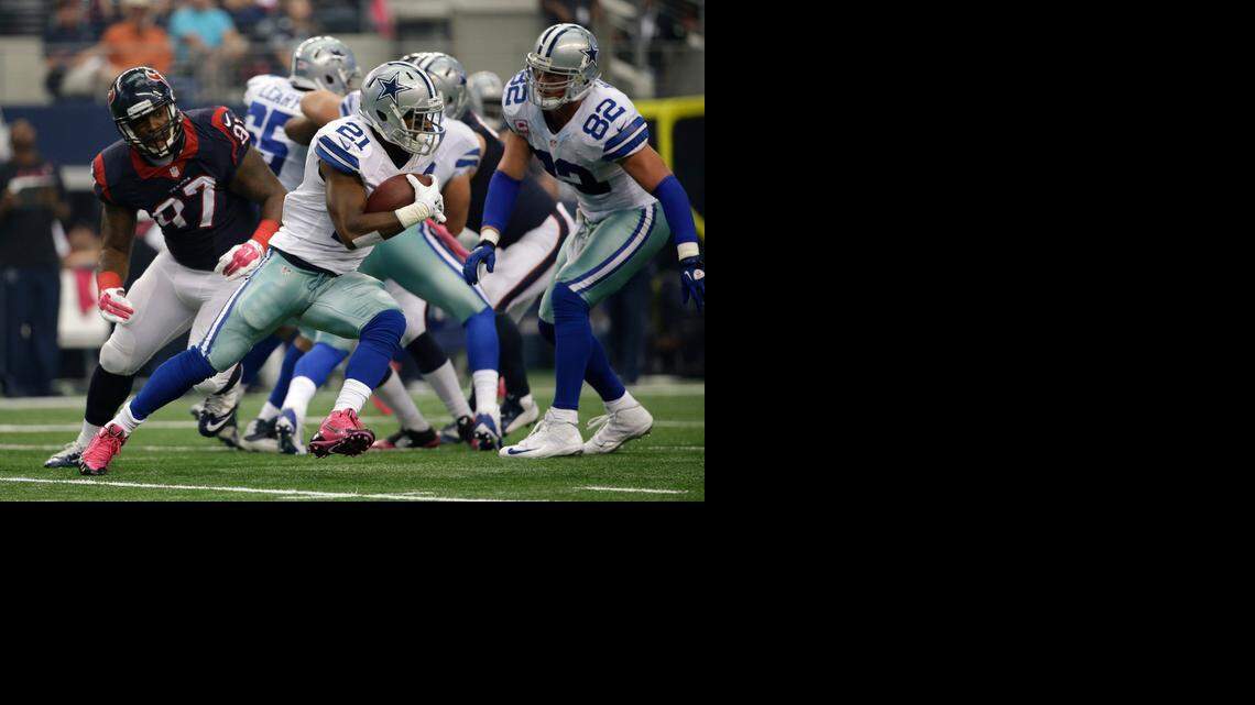 
Dallas Cowboys' Joseph Randle (21) sprints around the offensive line as Houston Texans' Jeoffrey Pagan (97) gives chase during a game Sunday in Arlington, Texas.
