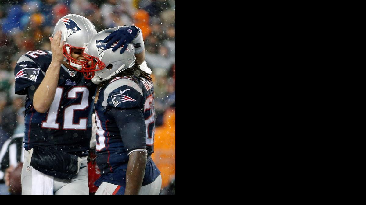 
New England quarterback Tom Brady (12) congratulates LeGarrette Blount after his touchdown during the second half of the AFC Championship against Indianapolis on Sunday in Foxborough, Mass.

