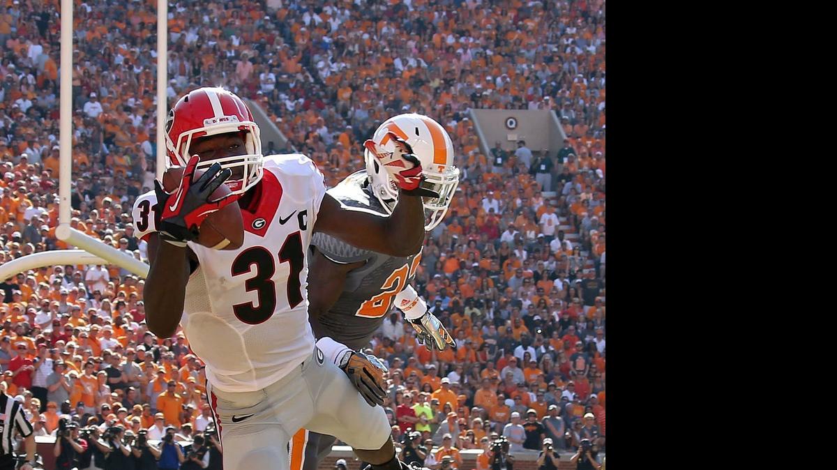 
Georgia wide receiver Chris Conley (31) makes a one-handed 1-yard touchdown pass in front of Tennessee defensive back Justin Coleman in the first at Neyland Stadium in Knoxville, Tennessee, on Saturday, October 5, 2013. 
