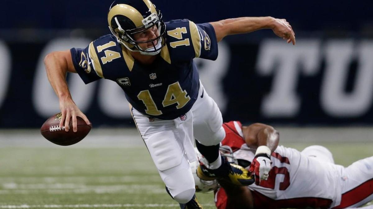 Shaun Hill (14) throws an incomplete pass for St. Louis in 2014 as he is tackled by Arizona Cardinals outside linebacker Alex Okafor.