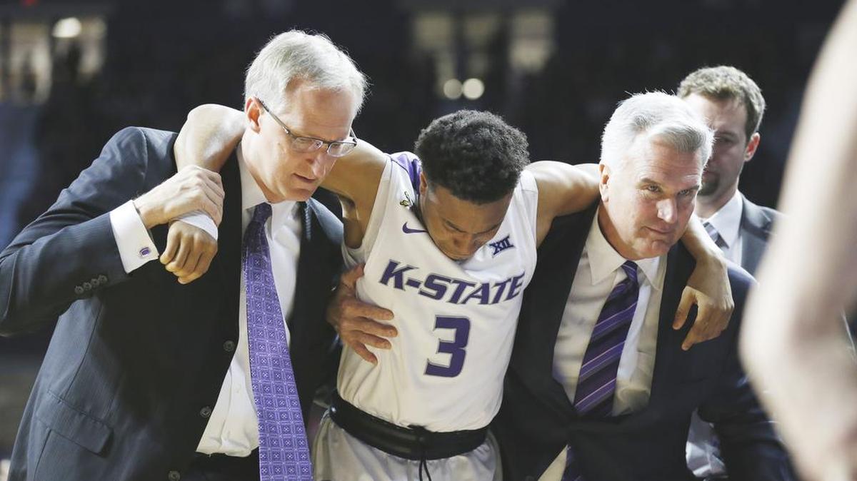 K-State guard Kamau Stokes (3) is helped from the court by K-State head coach Bruce Weber (right) after injuring his knee Saturday during the Mississippi-K-State game. (January 30, 2016)
