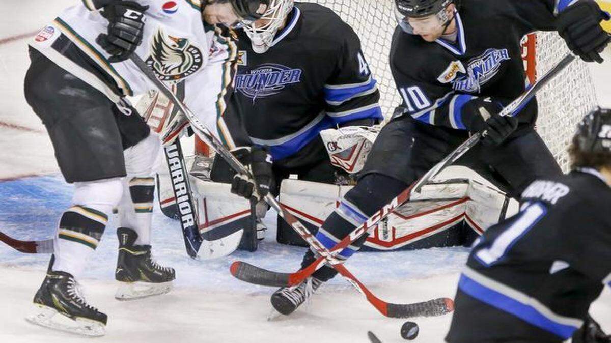 
The Thunder's Eric Meland, right, and Quad City's Jeff Lee battle in front of Thunder goalie Grant Rollheiser in the second period Wednesday at Intrust Bank Arena.
