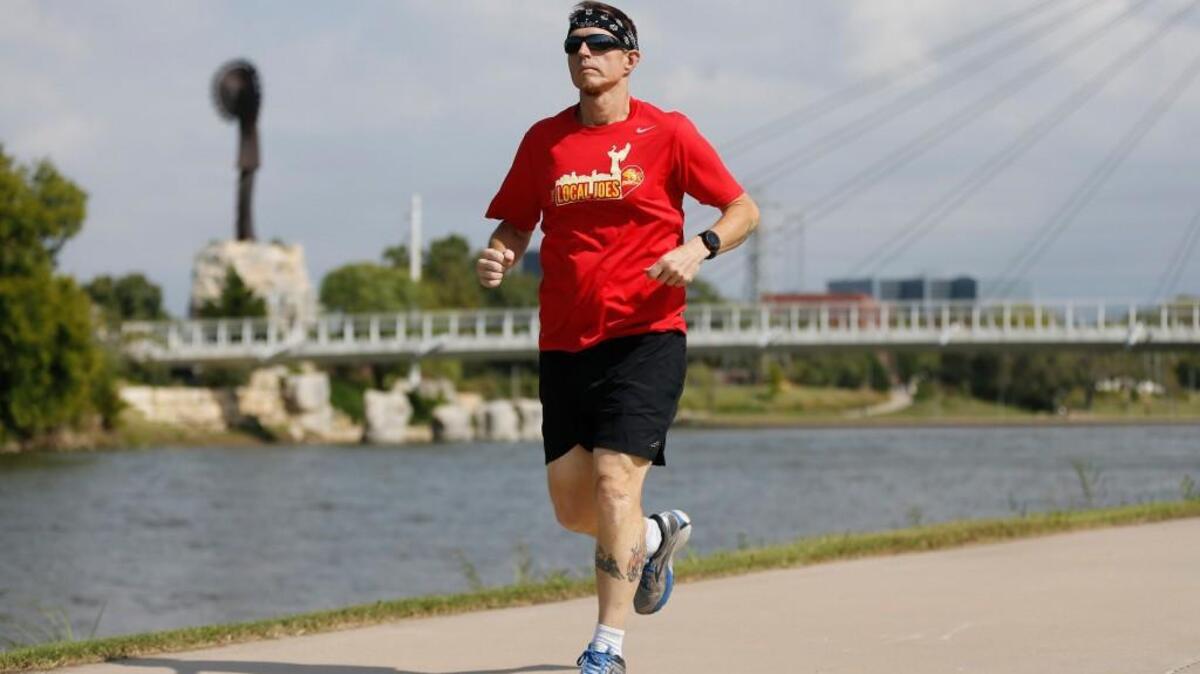 Brad Batemon runs along the Arkansas River on Tuesday. He has lost 135 pounds since he started training and will participate in this weekend's Prairie Fire Marathon.