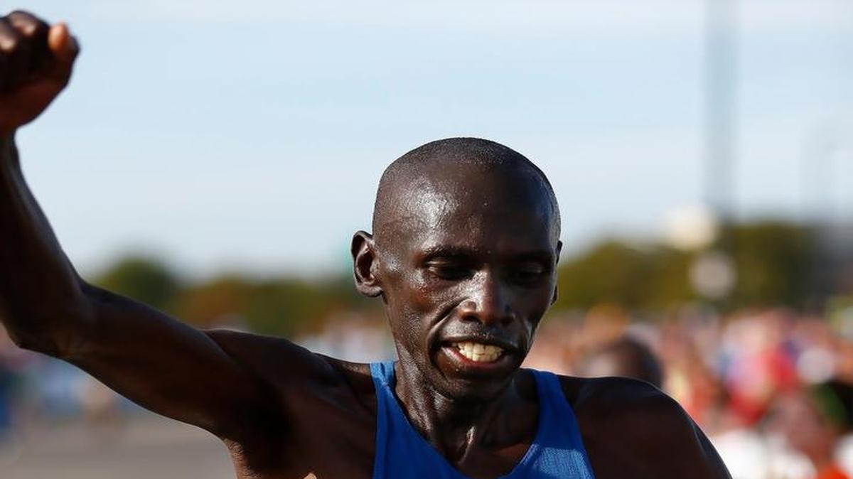 Stanley Boen raises an arm in victory as he finishes first in the Prairie Fest Marathon in 2015 with a time of 2:20:47.