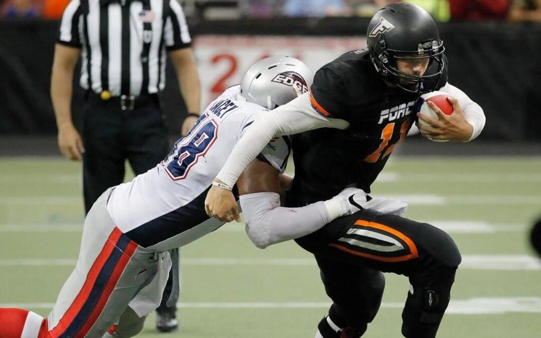 Force quarterback David Olson tries to shake off Bloomington's Christian Lacey in the second quarter of the Champions Indoor Football semifinals at Intrust Bank Arena.