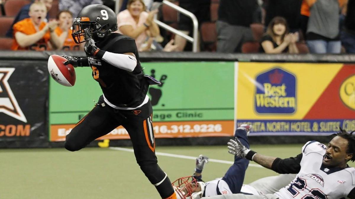The Force’s Clarence Anderson scores a touchdown against Bloomington’s Dominic Mcuffie falls down in the first quarter Saturday night at Intrust Bank Arena.