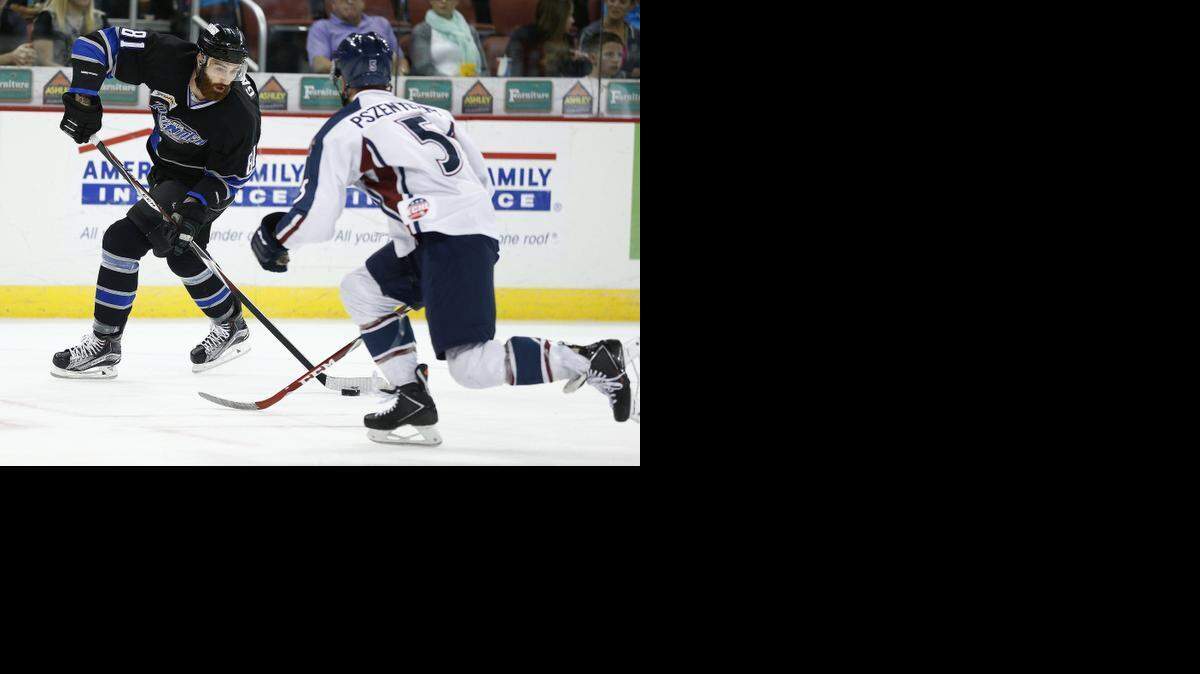 
The Thunder's Danick Gauthier, left, brings the puck up the ice as Tulsa's Dave Pszenyczny defends Sunday night at Intrust Bank Arena. 
