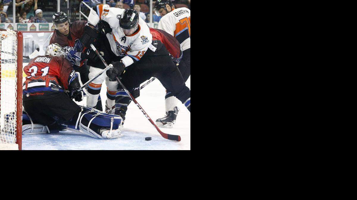
Wichita Thunder goalie Tim Boron, left, Michael Trebish, near left, and Dan Milan, right, converge on the Mavericks’ Josh Brittain to prevent a goal in the second period Friday night at Intrust Bank Arena.

