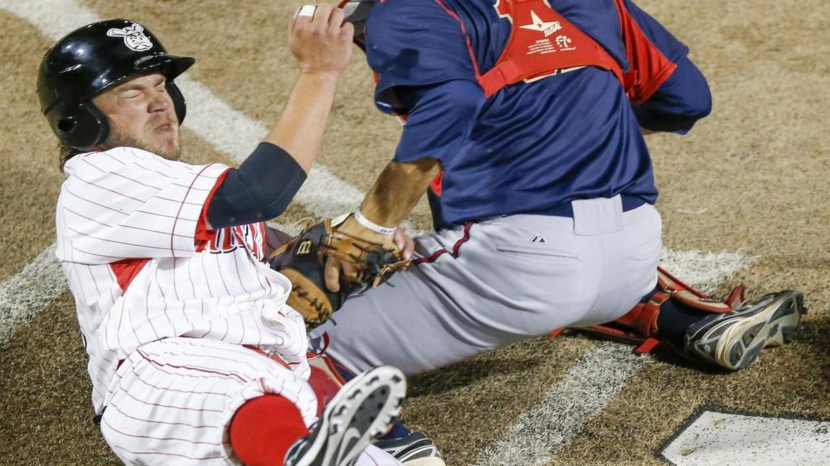 
The Wiungnuts' Joash Brodin gets stopped by Lincoln catcher Mitch Canham before he reaches home plate in the seventh inning Friday at Lawrence-Dumont Stadium. 
