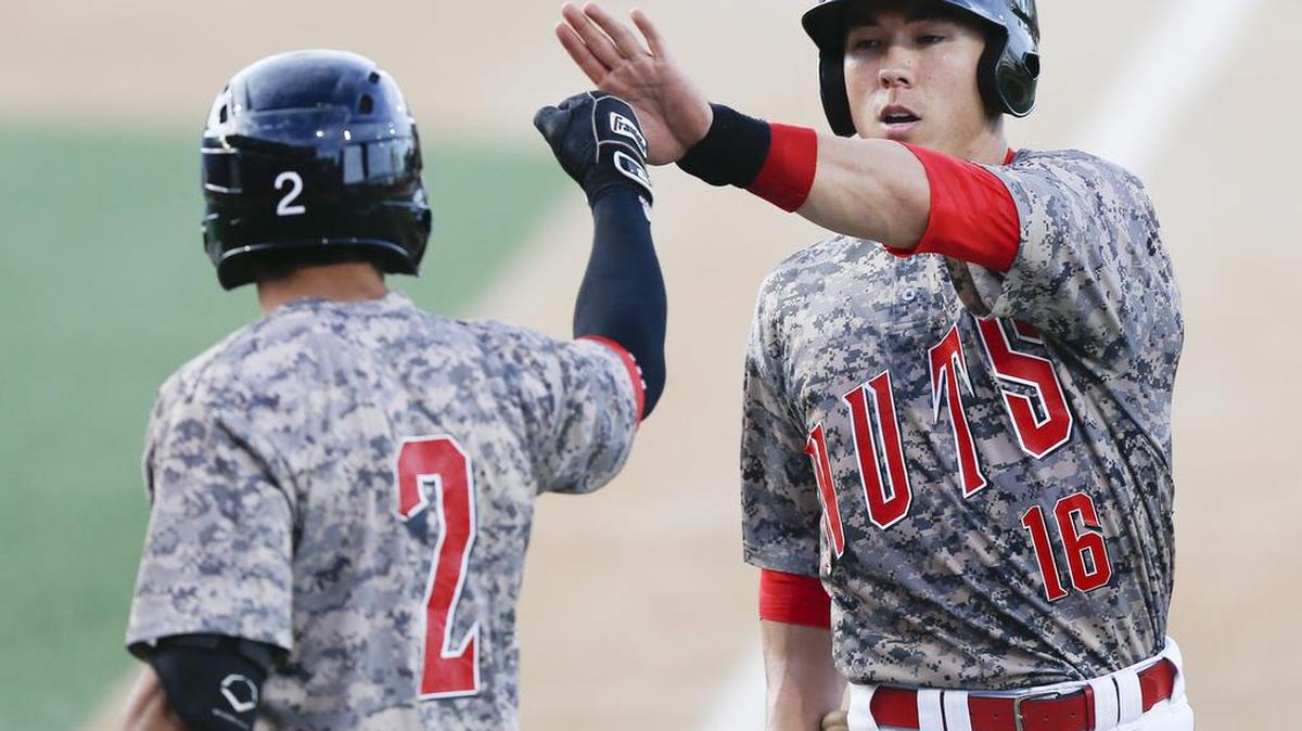 
The Wingnuts' Brent Dean (16) gets congratulated by teammate Leo Vargas after scoring in the 2nd inning at Lawrence-Dumont Stadium Wednesday. The Wingnuts won 3-1. (Aug. 12, 2015) 
