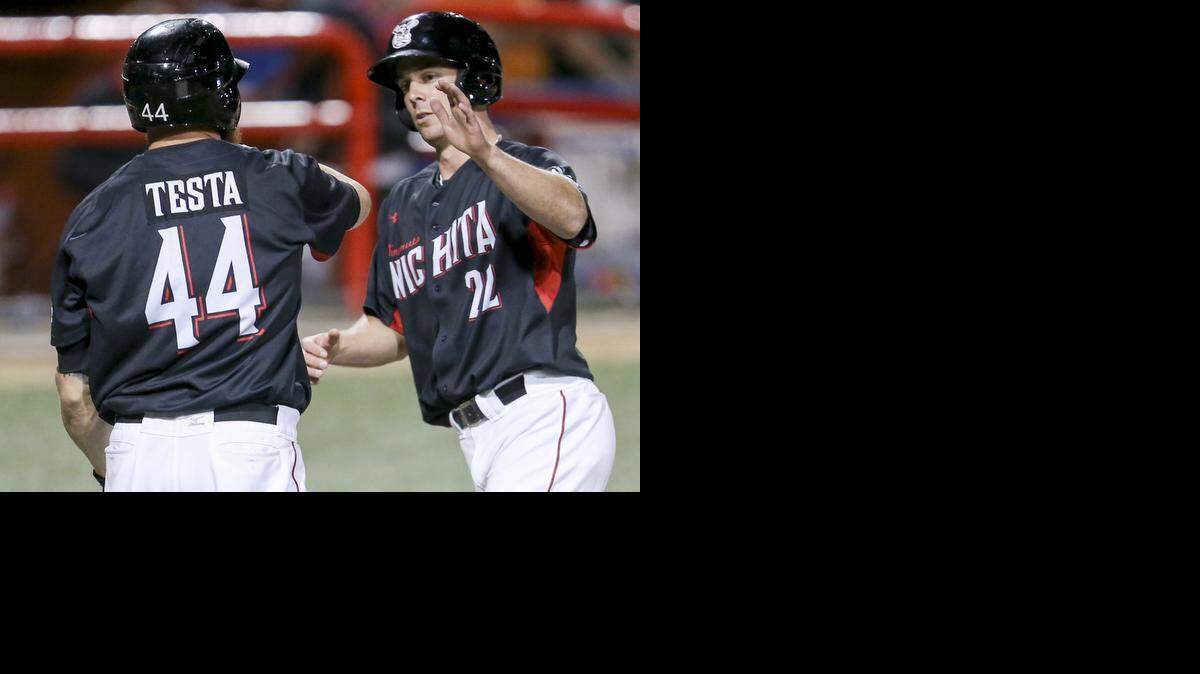 
The Wingnuts' Brent Clevlen (22) gets congratulated by teammate Carlo Testa after scoring against Laredo in the seventh inning Saturday at Lawrence-Dumont Stadium.
