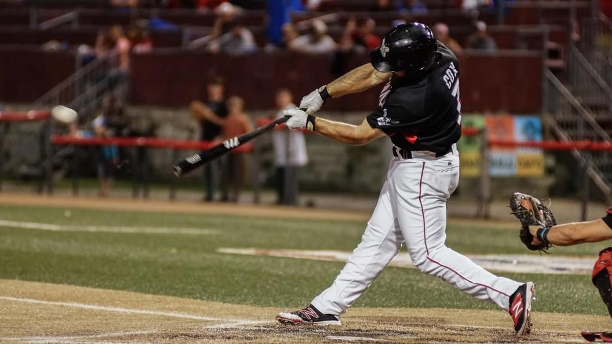 Wingnuts infielder Zack Cox drives the ball into center field in the third inning against Sioux City on Saturday night at Lawrence-Dumont Stadium.