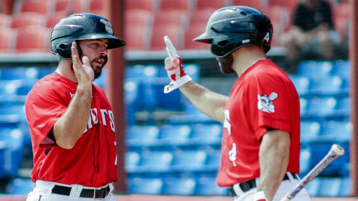 Zack Cox, left, high-fives Wingnuts teammate Harrison Kain in the bottom of the second inning after Cox scored against the T-Bones pitching on Thursday afternoon at Lawrence-Dumont Stadium.