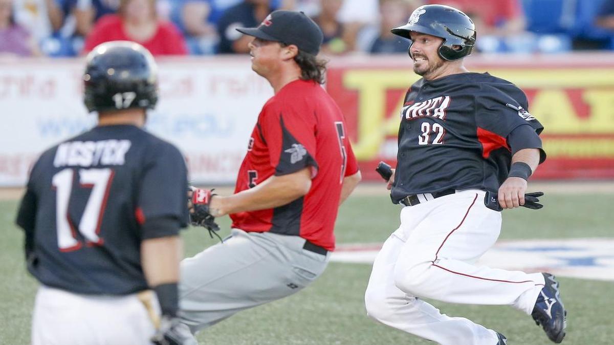 
The Wingnuts' Andy LaRoche slides to the plate ahead of Grand Prairie pitcher T. J. Bozeman after a wild pitch in the fourth inning Tuesday at Lawrence-Dumont Stadium. 
