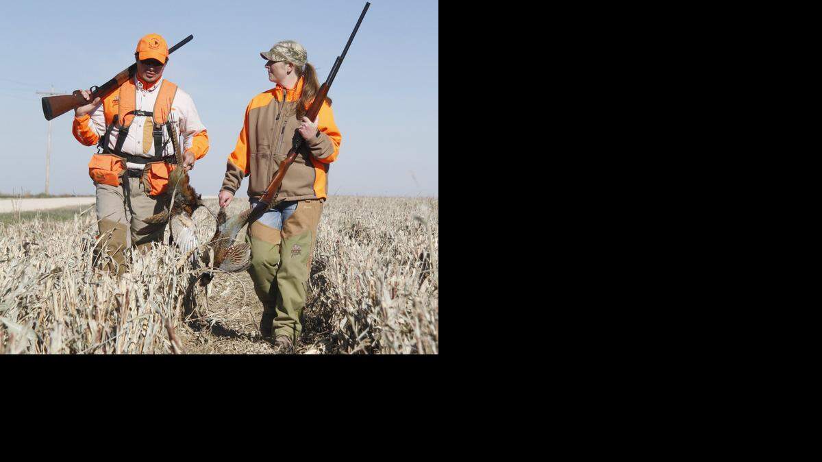 
Tyson, left, and Casey Seirer walk from a field where he shot two pheasants on Sunday's opening day.
