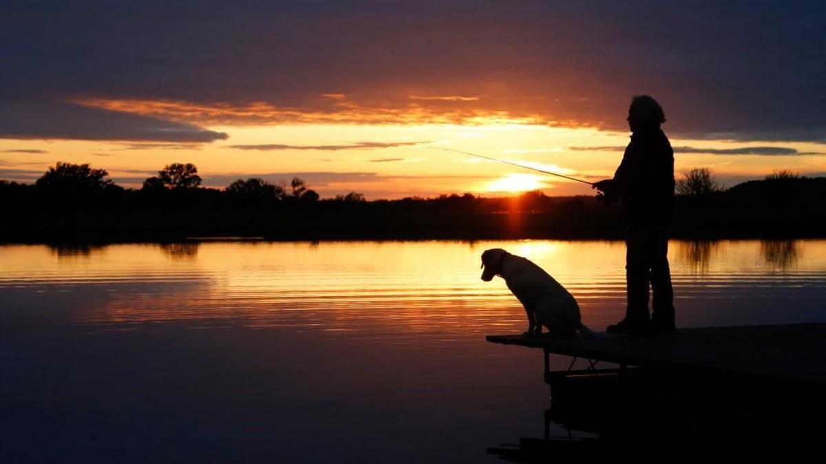 Gary Regan, and Maxine, fish during a sunset at Timber Hills Lake Ranch. The ranch offers fishing in more than 20 ponds and lakes to guests who rent a cabin.