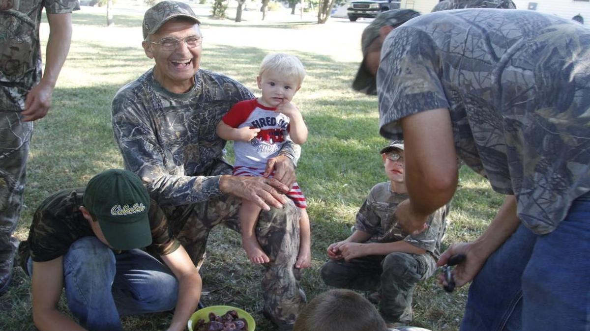 
Max Burnham, center, laughs as he watches kids clean doves Saturday morning on a youth hunt he's been hosting for more than 20 years. 
