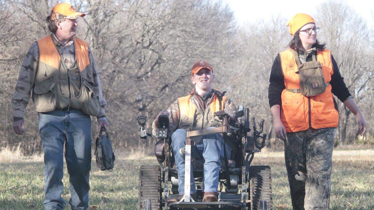 Jak Kerschen, who is quadriplegic, pilots a track chair to a hunting blind on Dec. 7. He is accompanied his father, Denny Kerschen, left. On the right is Jessica Rice of the Adaptive Sportsmen of Kansas, the group that brought the track chair that allows disabled hunters to get afield.