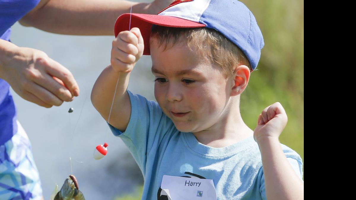 
Harry Hoover admires a fish he caught during the Wichita Eagle's Kids Fishing Clinic at the Great Plains Nature Center on Saturday.
