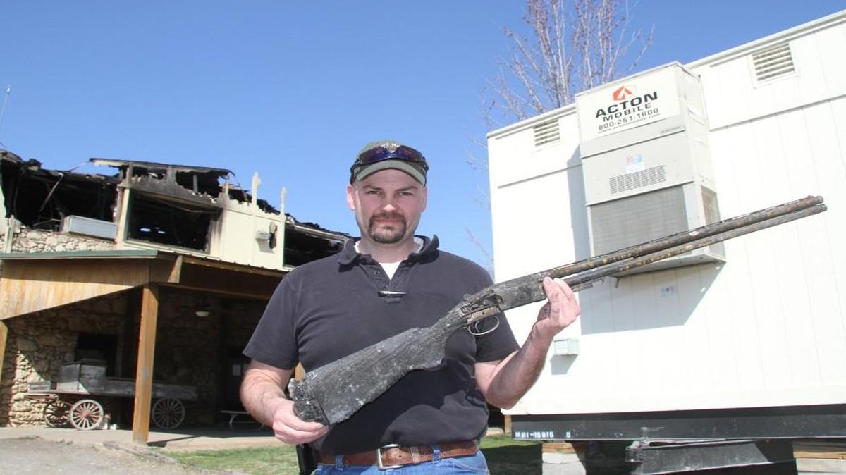 Marc Murphy holds a shotgun damaged in the March 3 fire at his gun shop. Shotgun target ranges opened again on Thursday. Guns not damaged in the fire are also for sale.