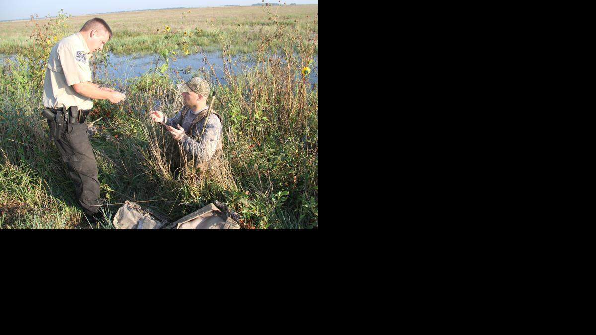 
Game warden Hal Kaina checks a hunter’s license at the McPherson wetlands. Many of Kaina’s co-workers have left their jobs as game wardens because of low, stagnant pay and understaffing.
