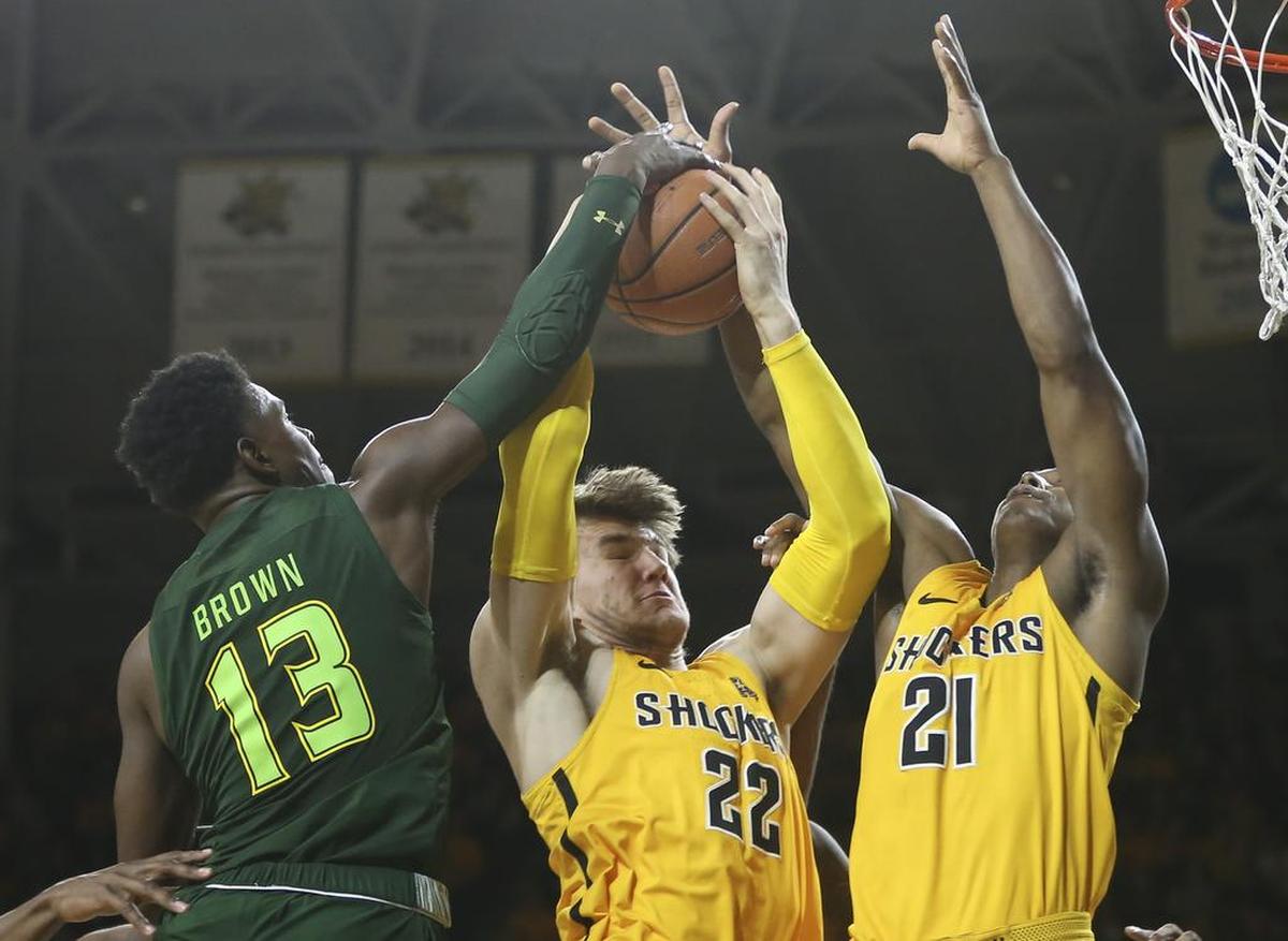 Wichita State center Asbjorn Midtgaard grabs a rebound against South Florida guard Justin Brown during the second half of their game at Koch Arena on Sunday afternoon.