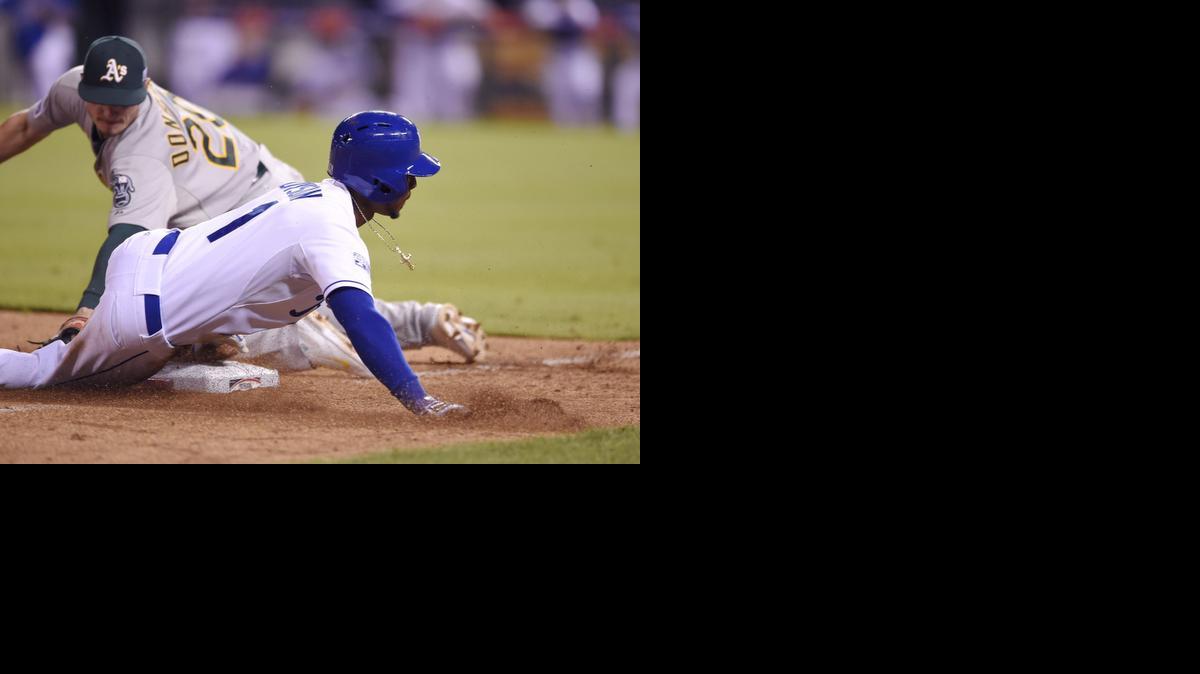 
Kansas City’s Jarrod Dyson slides safely into third base ahead of the tag by Oakland third baseman Josh Donaldson during the ninth inning in the American League Wild Card game Tuesday in Kansas City, Mo.
