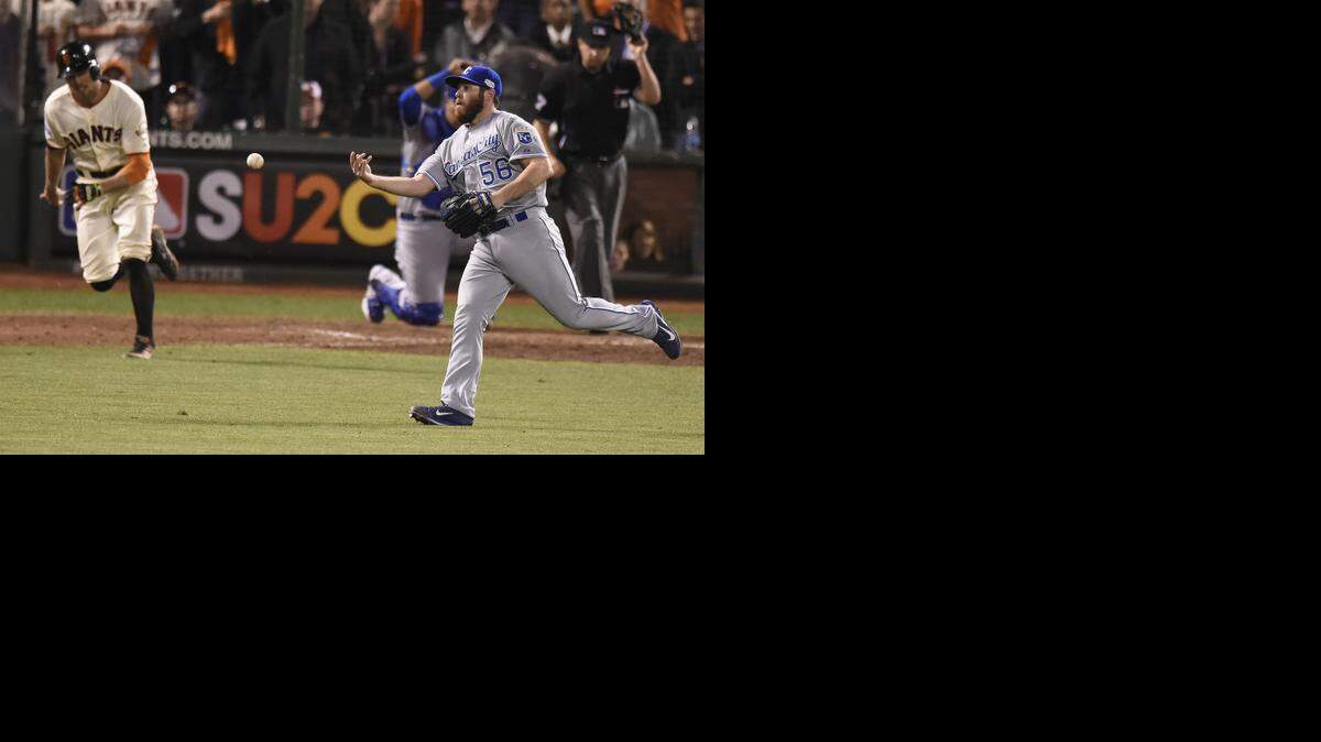 
Royals closer Greg Holland flips the ball to first baseman Eric Hosmer to retire the Giants' Hunter Pence in the ninth inning.
