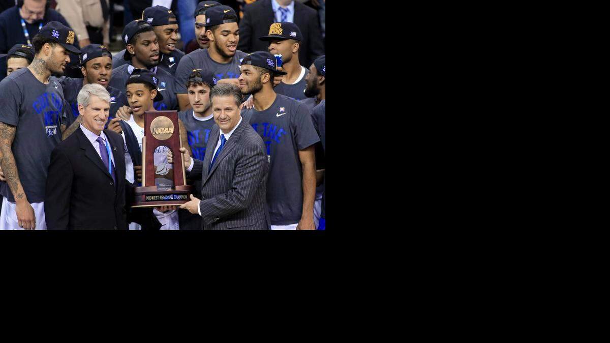 
Kentucky coach John Calipari, right, holds the regional championship trophy after the team's 68-66 win over Notre Dame last week.
