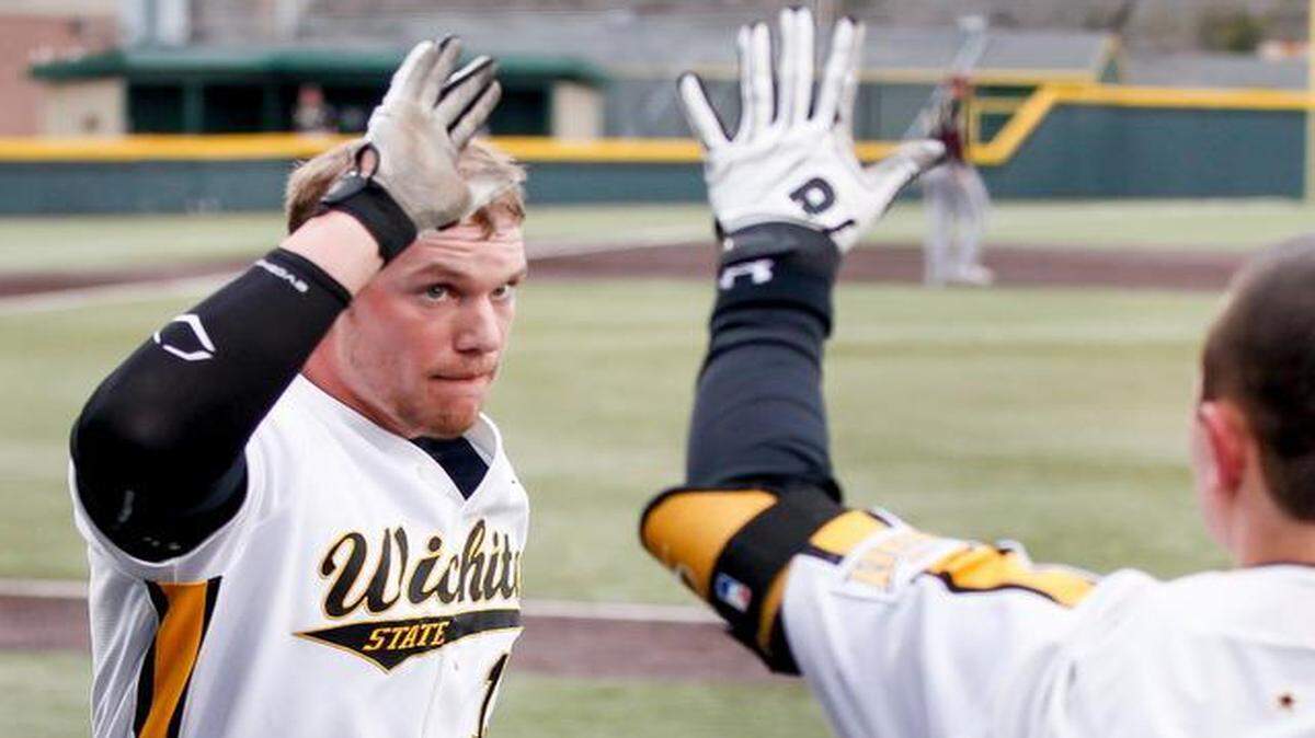 
Wichita State's Chase Rader, left, is congratulated after scoring against Texas State during the second game Friday at Eck Stadium.
