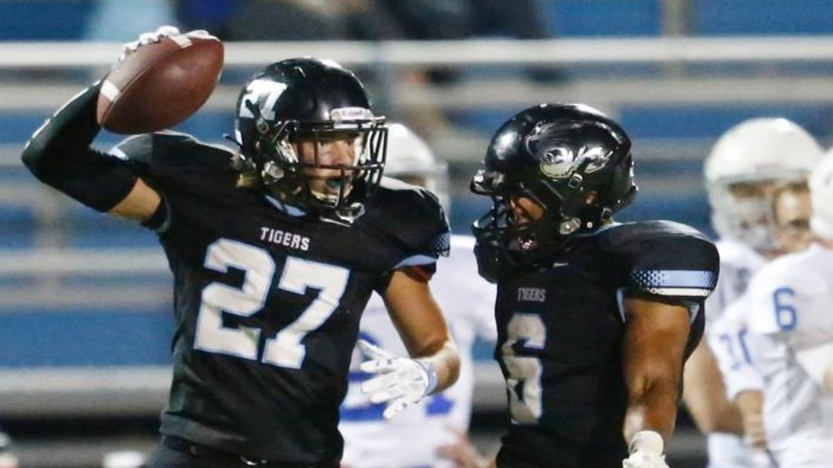 Eisenhower's Noah Strunk (27) and Drake Damon (6) celebrate Strunk’s interception against Andover in September.