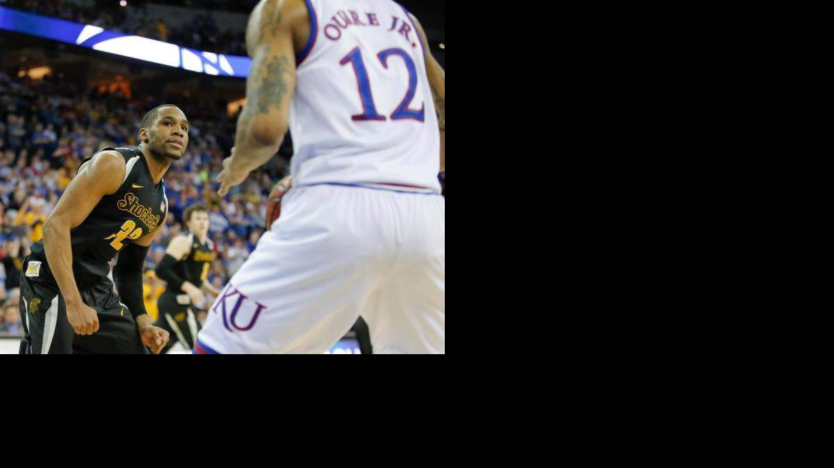 
Wichita State guard Tekele Cotton looks back at Kansas guard Kelly Oubre after Cotton sliced to the basket and scored during the second half against Kansas on Sunday.
