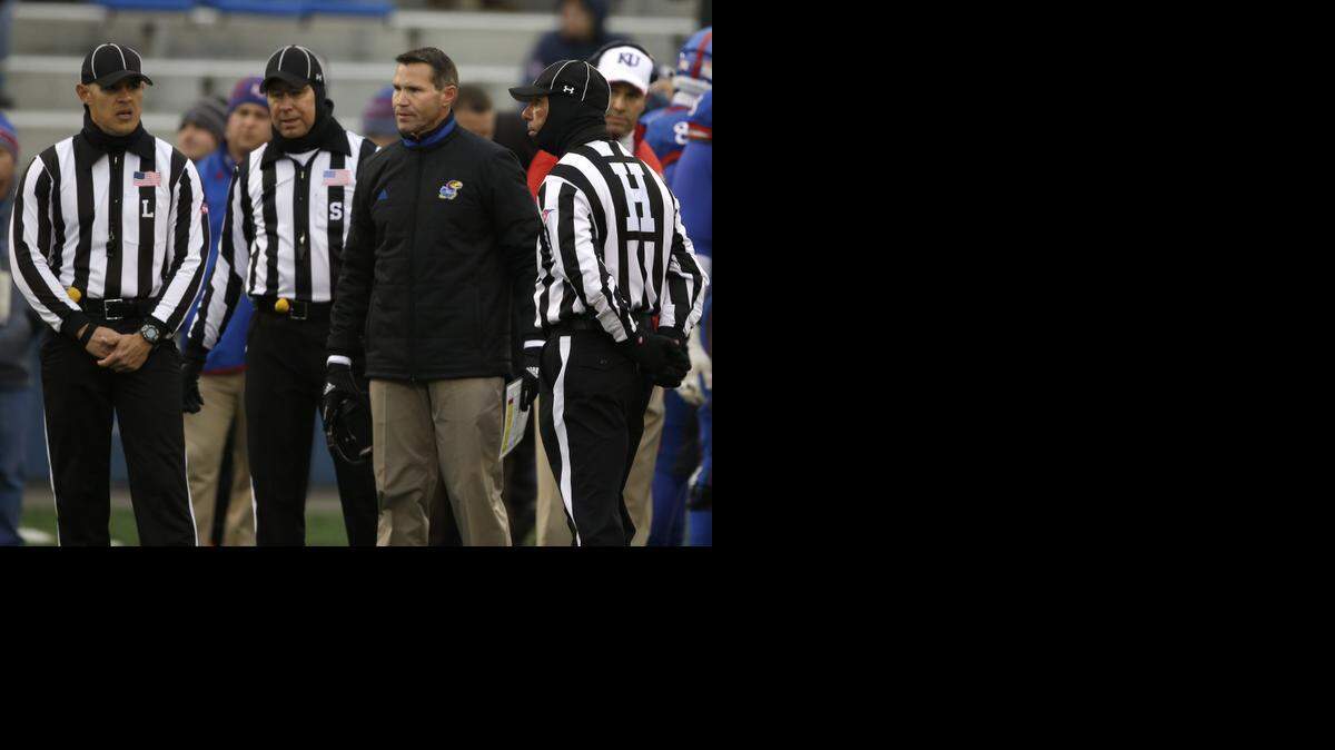 
Kansas interim coach Clint Bowen stands with game officials during a play review in the first half Saturday in Lawrence.
