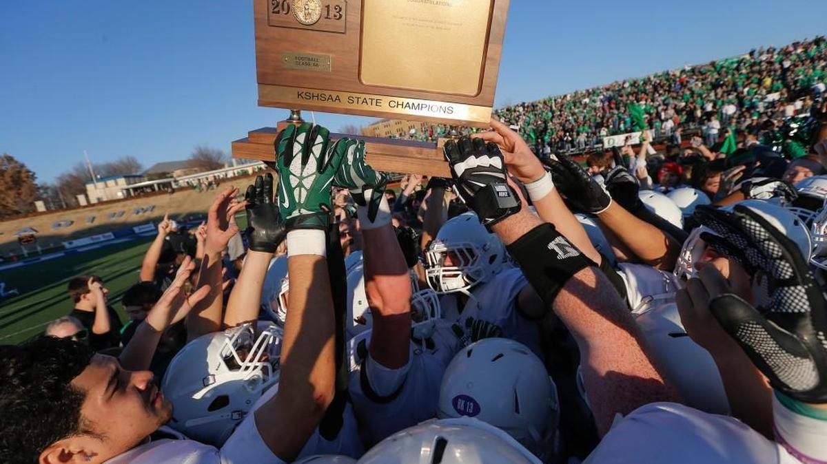 Derby players hold up the 2013 Class 6A championship trophy. Eight football champions will be crowned in Kansas in November.