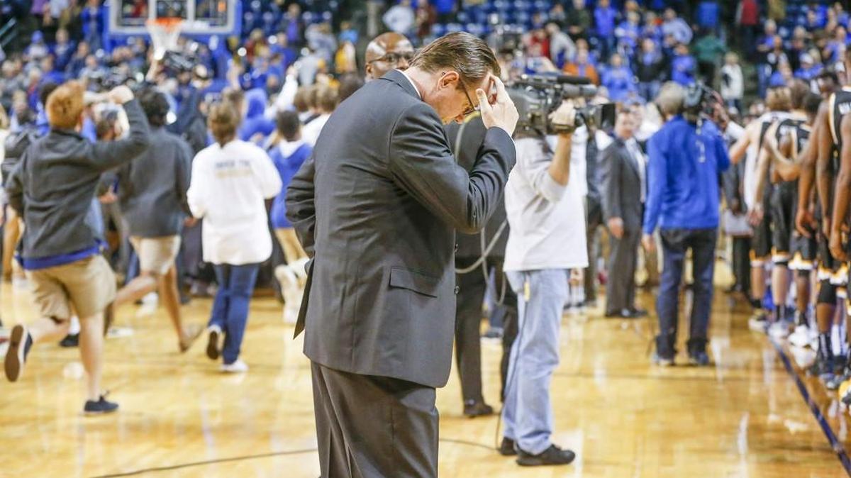 Wichita State coach Gregg Marshall holds his head as Tulsa students rush the court after Tuesday’s game in Tulsa.