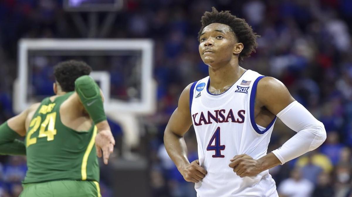 Kansas guard Devonte' Graham walks off the court while Oregon forward Dillon Brooks begins to celebrate a 74-60 win against the Jayhawks on Saturday at the Sprint Center in Kansas City, Mo.